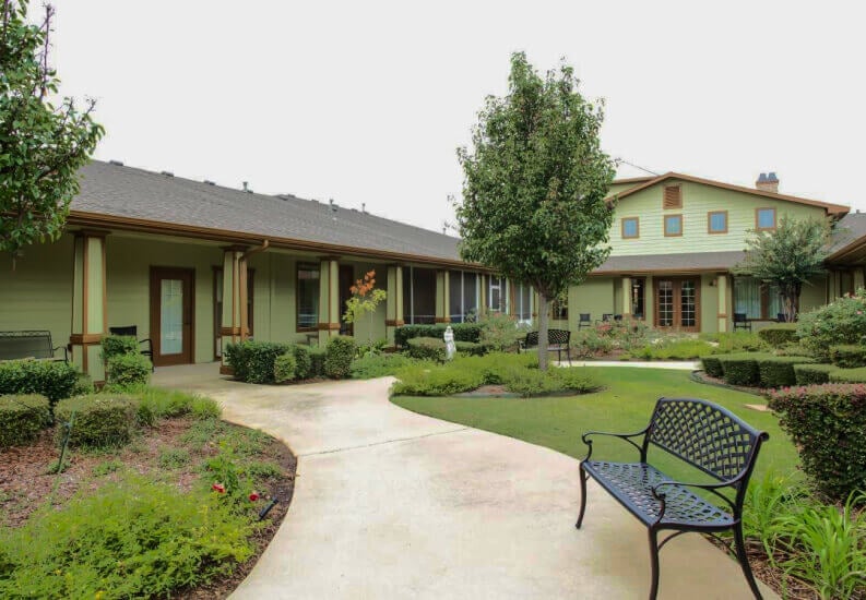 Outdoor Courtyard with Walking Path and Bench for Seniors at Assisted Living Facility