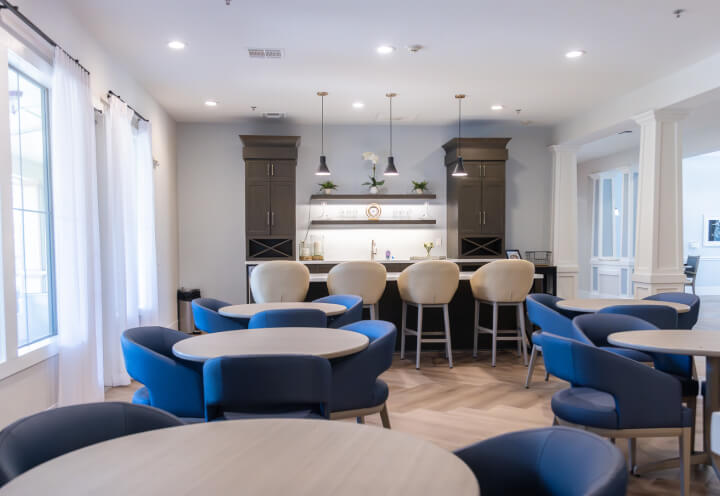 Bistro Bar with Blue Seating and Pendant Lights for Seniors at Assisted Living Facility Bistro Bar with Blue Seating and Pendant Lights for Seniors at Assisted Living Facility