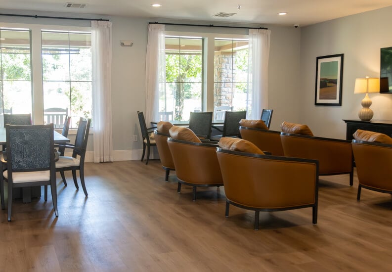 Common Room with Leather Club Chairs and Natural Light for Seniors at Assisted Living Facility Common Room with Leather Club Chairs and Natural Light for Seniors at Assisted Living Facility