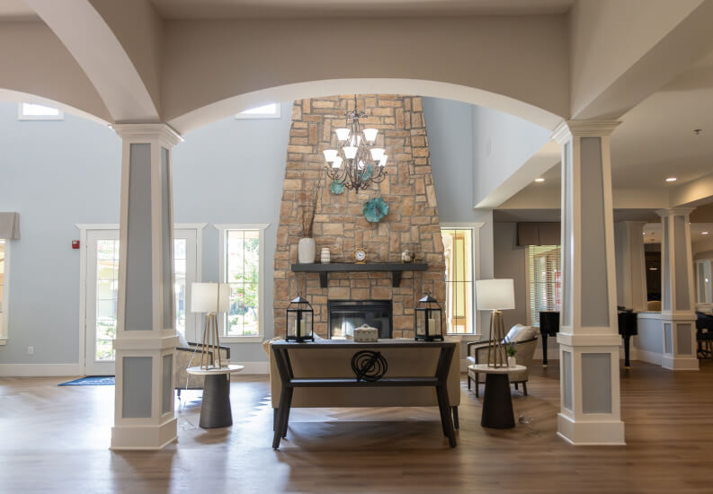 Lobby Entrance with Stone Fireplace and Arched Columns for Seniors at Assisted Living Facility Lobby Entrance with Stone Fireplace and Arched Columns for Seniors at Assisted Living Facility
