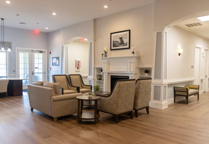 Memory Care Lounge with White Fireplace and Neutral Seating for Seniors at Memory Care Facility
