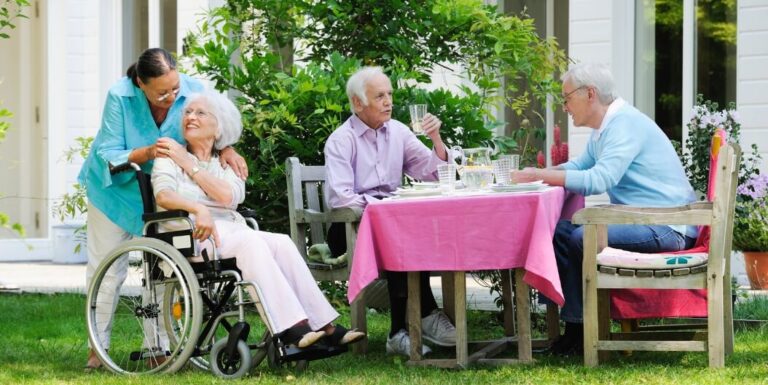 Group of Elderly Residents Dining Outdoors at Memory Care Facility