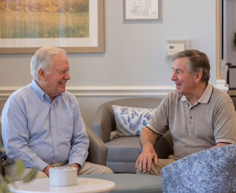 Two Elderly Men Socializing in Common Lounge at Assisted Living Facility