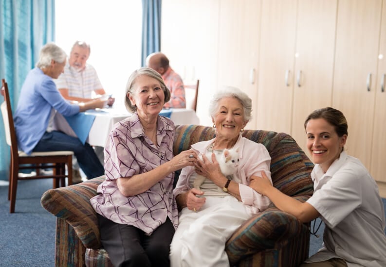 Smiling Senior Women With Their Female Nurse at Assisted Living Facility Smiling Senior Women With Their Female Nurse at Assisted Living Facility